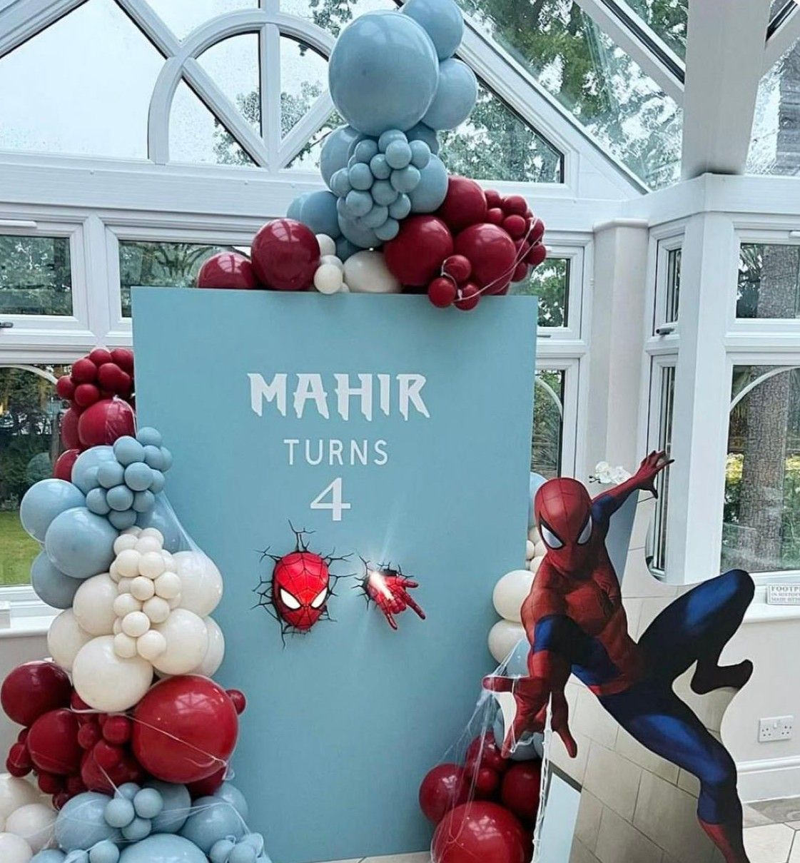 Spider-Man themed 4th birthday party backdrop for Mahir with red, white, and blue balloon garland decorations.
