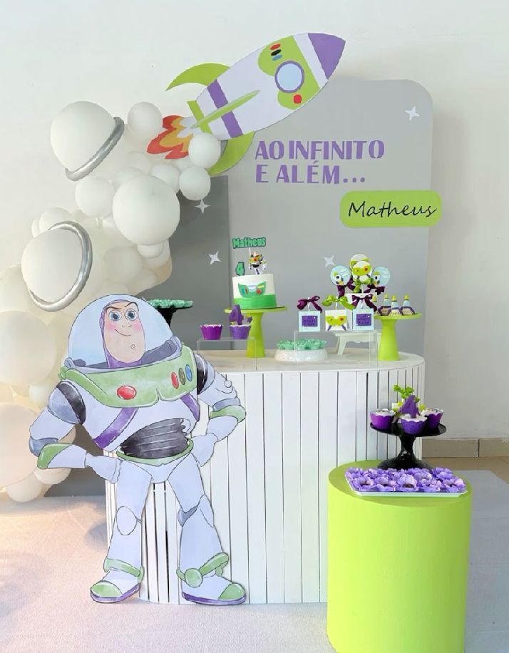 Toy Story themed party decorations featuring Buzz Lightyear figures and green and purple balloon arrangements.