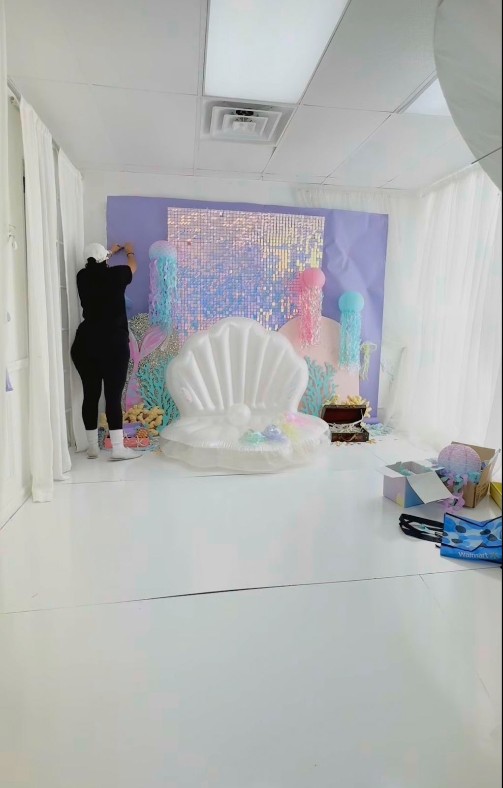 White photography studio setup with purple backdrop and seashell throne prop.