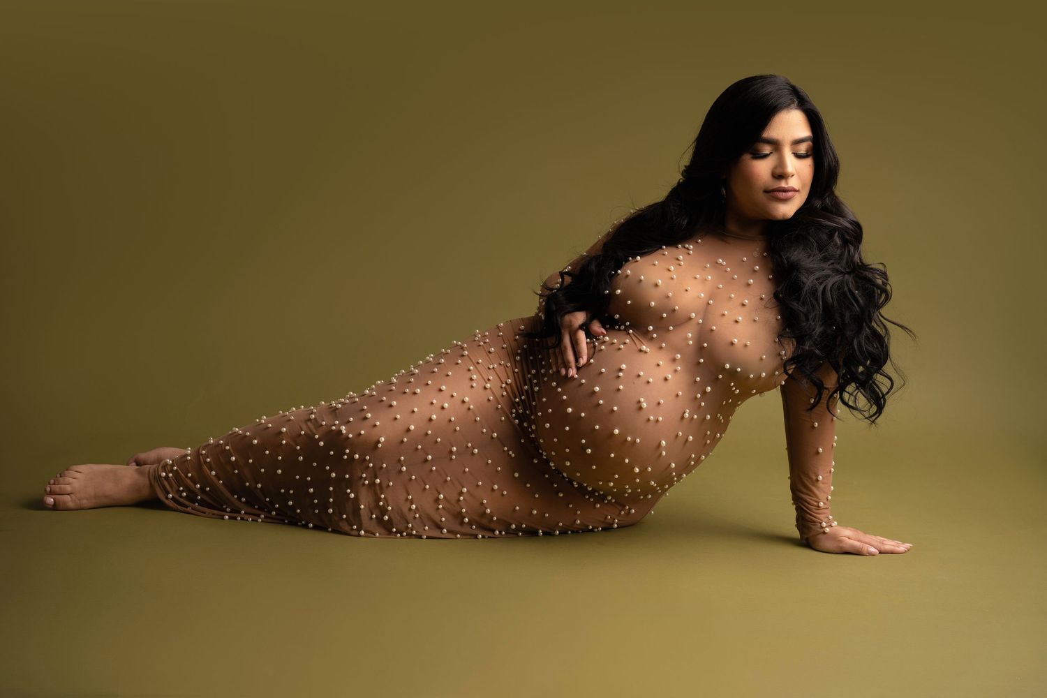 A silhouetted figure poses gracefully against a warm sepia-toned background in an artistic portrait.