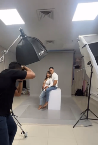 Behind-the-scenes view of a photography studio setup with lighting equipment and reflectors during a professional shoot.