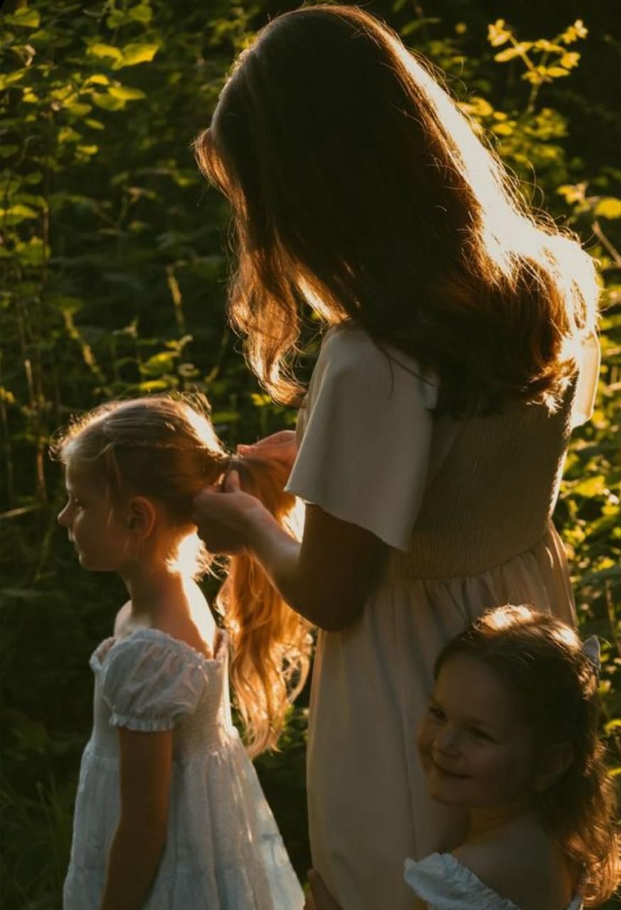 Backlit silhouettes share intimate moments in a golden-hour garden setting with sunlit foliage.