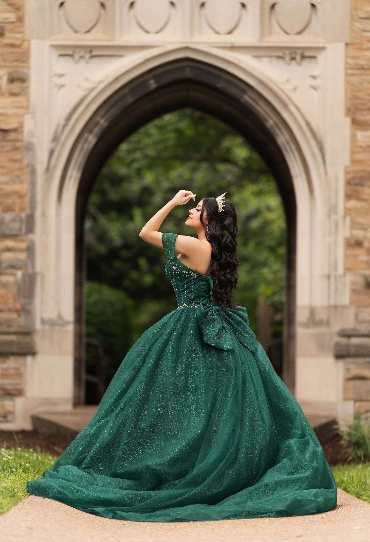 Stunning emerald green ball gown shown from various angles against stone archways and garden backdrop.