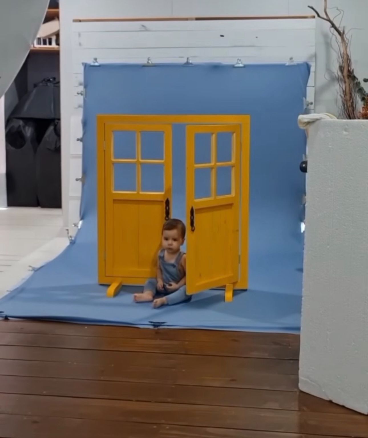 Series of photos showing a playful scene with yellow windows against a blue wall and wooden floor.