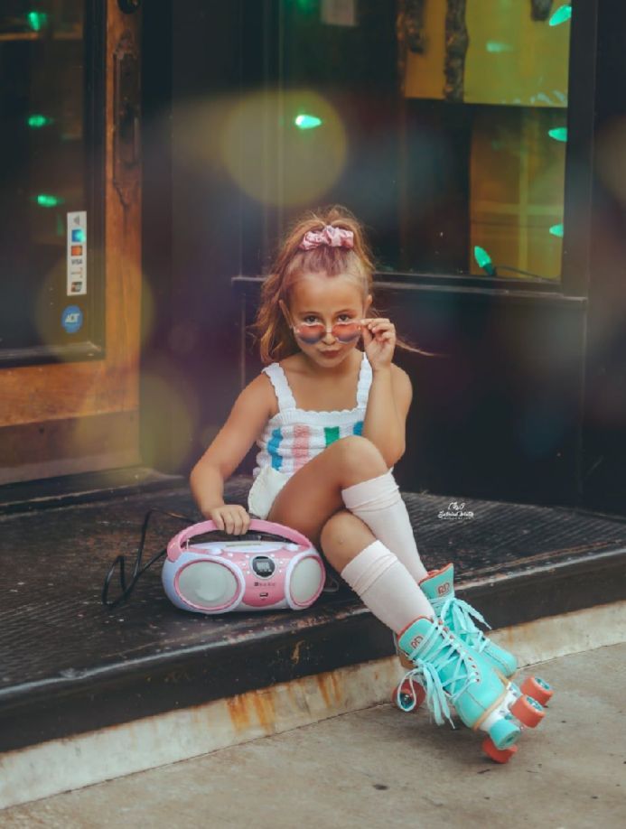 A retro-styled scene with roller skates, knee socks, and a boombox on urban steps with teal lighting effects.