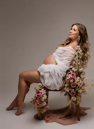 Artistic boudoir photo series showing figure in white sheer dress with floral arrangements on vintage wooden chair.