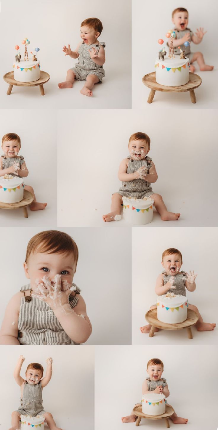 Baby in gray outfit celebrates first birthday with small white cake decorated with colorful bunting on wooden stool.