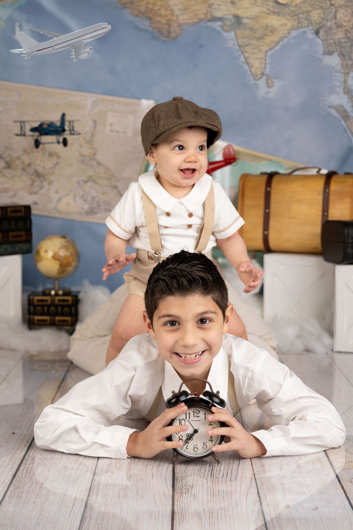 Adventure themed photoshoot with travel decor, map background and vintage suitcase props.