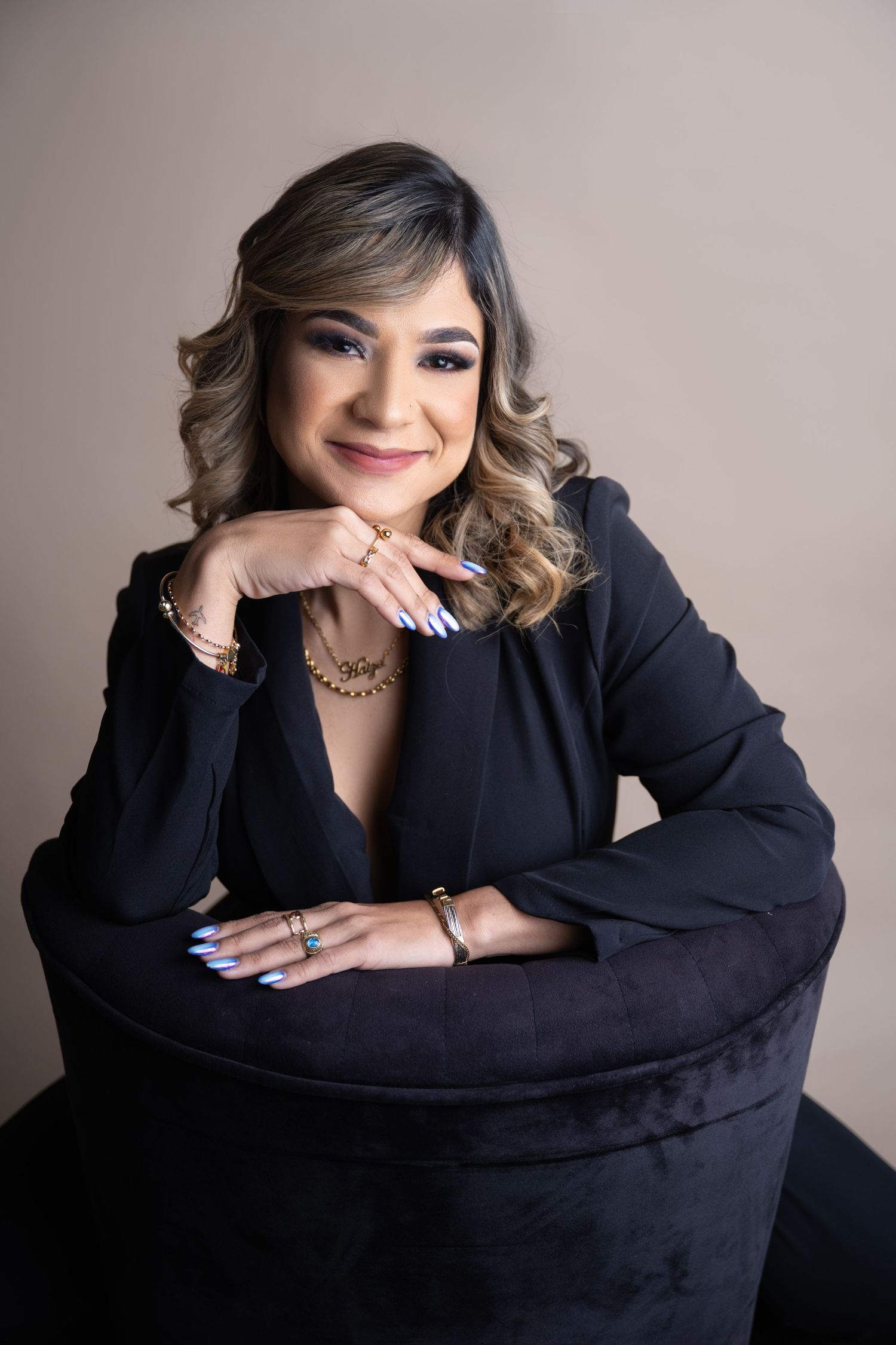 Professional headshot featuring soft waves and elegant makeup in dark attire.