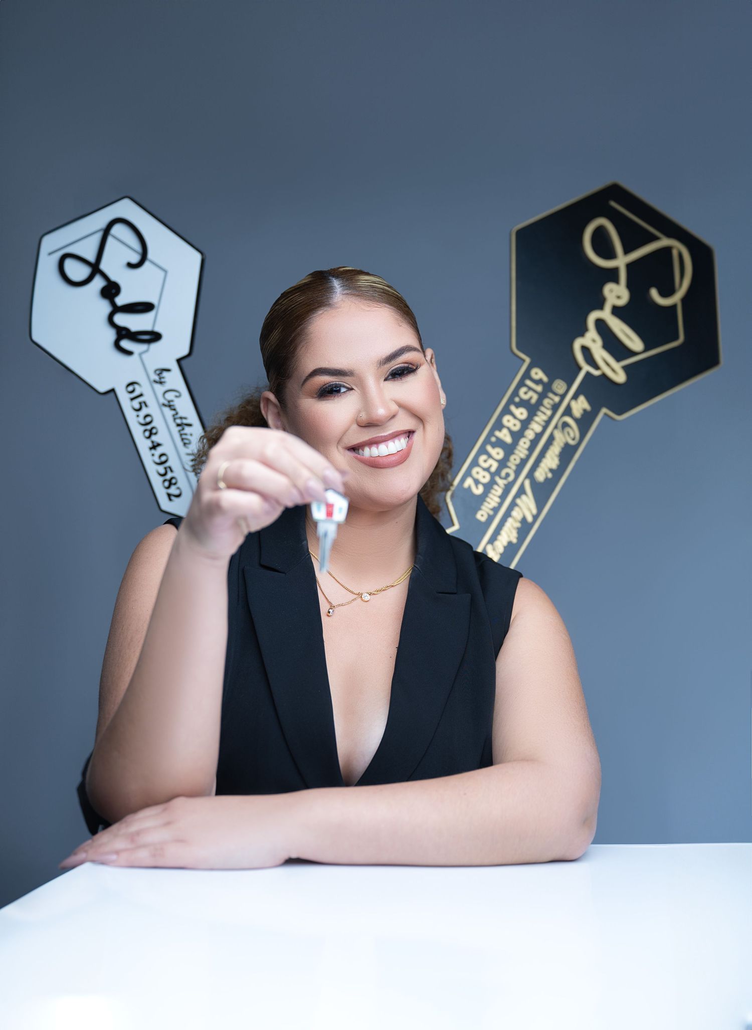 Professional portrait with decorative key props against a blue background.