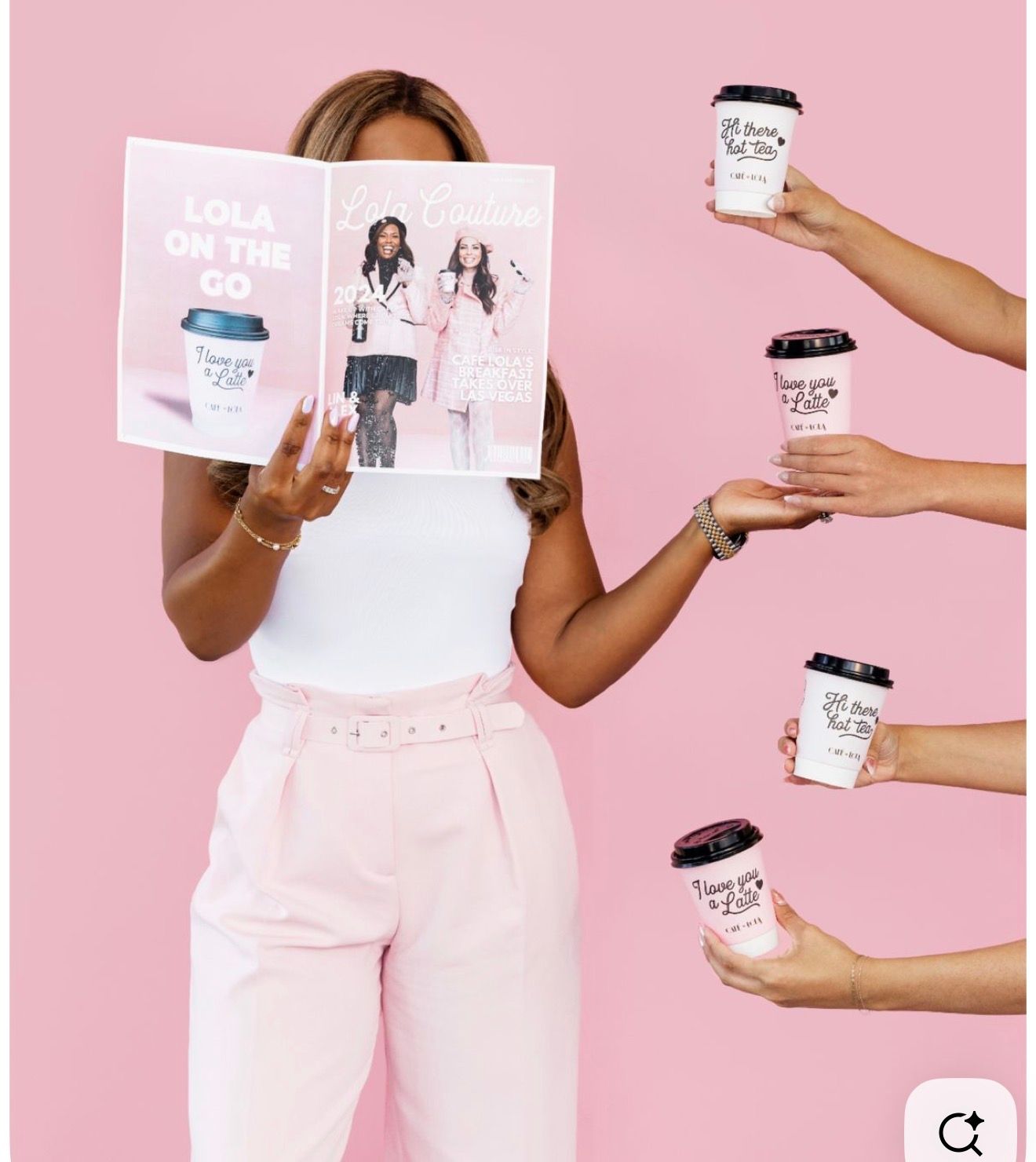 Woman holding Lola On The Go magazine with branded coffee cups on pink background.