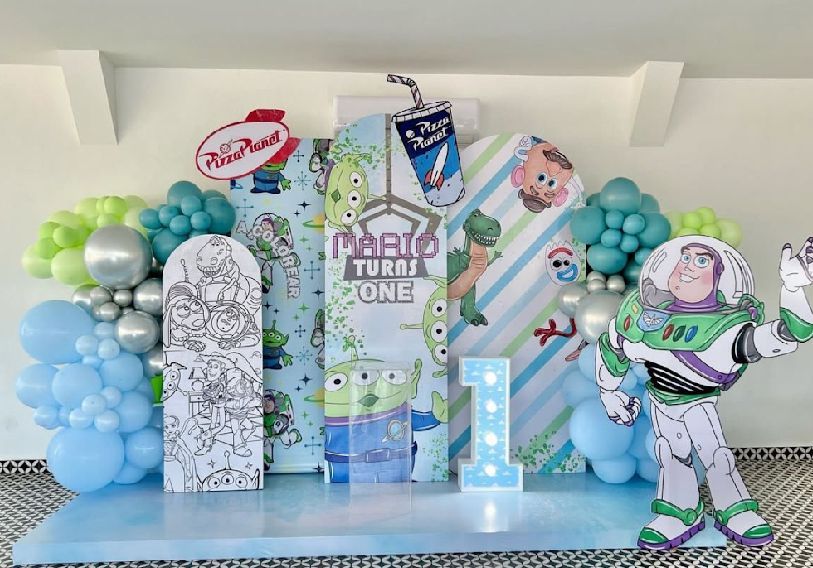 A Toy Story themed party setup with blue and white balloon garlands and decorative backdrops.