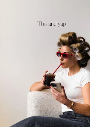 Woman in white shirt lounges on couch while smoking an electronic cigarette.