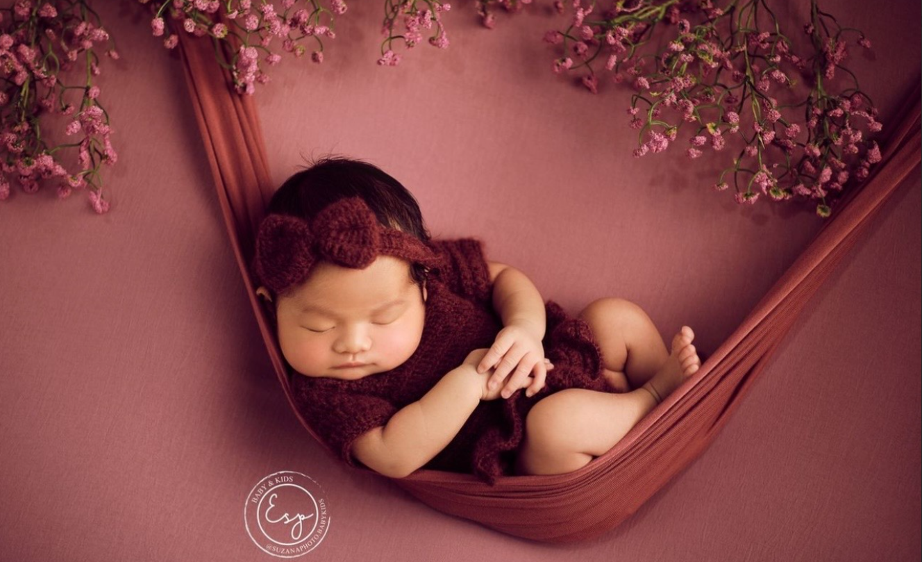 A collection of soft, dreamy newborn photography poses set against a pink and burgundy backdrop.