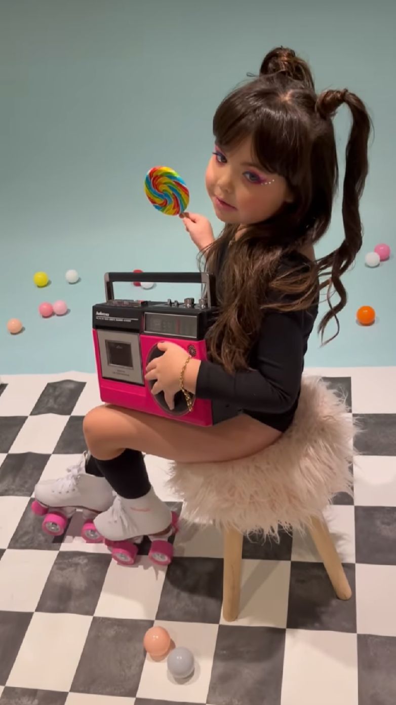 Checkered floor photoshoot setup with pink props and scattered colorful candies.