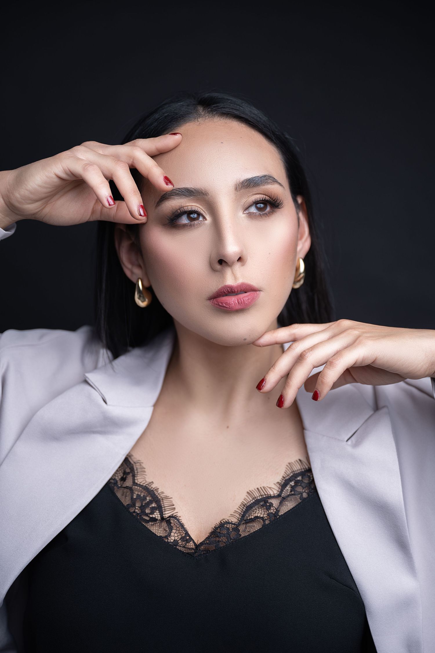 Glamorous beauty portrait featuring neutral makeup and a black lace top with white blazer.