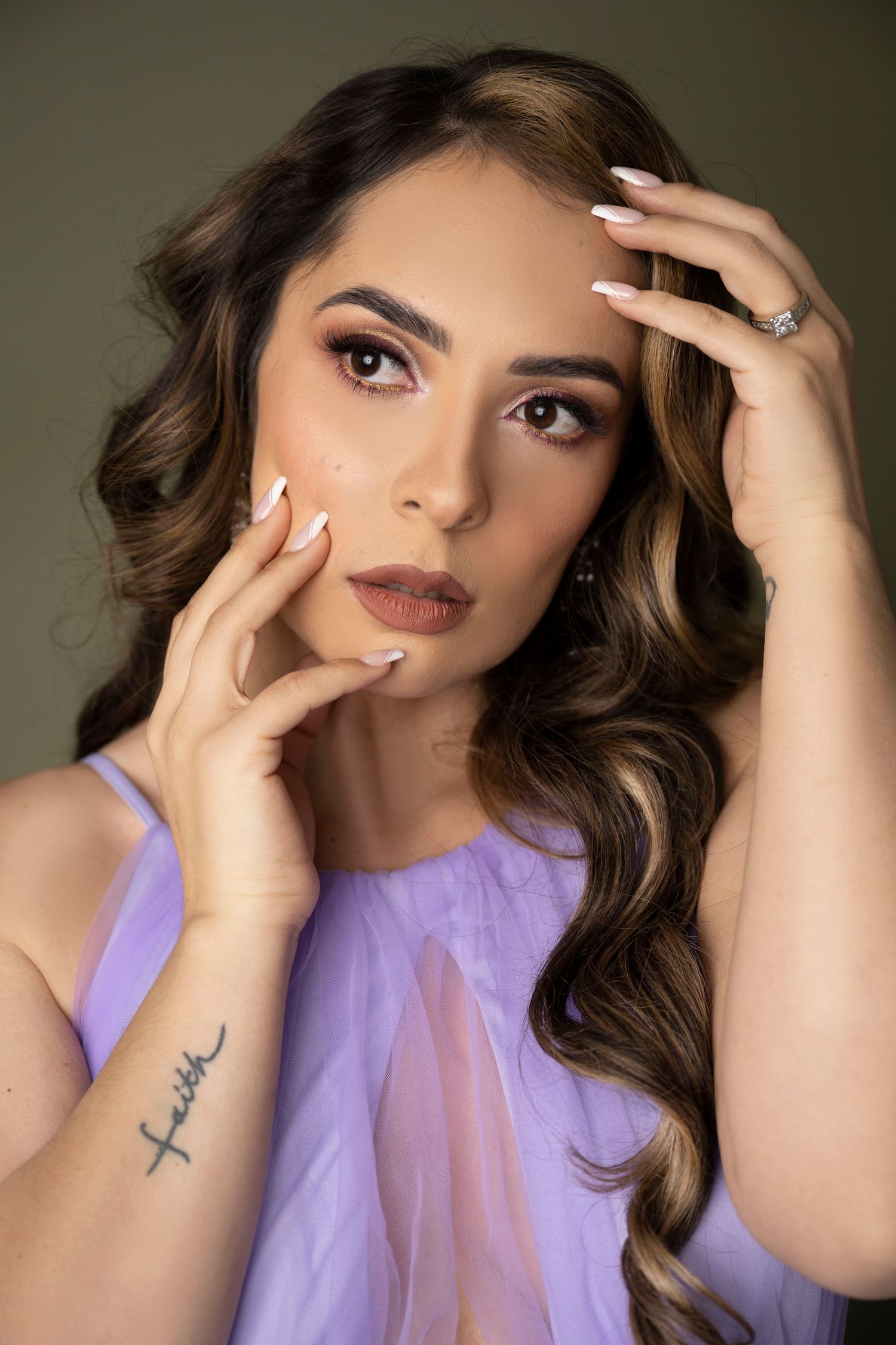 Close-up beauty portrait in purple dress showing styled waves and glamorous makeup.