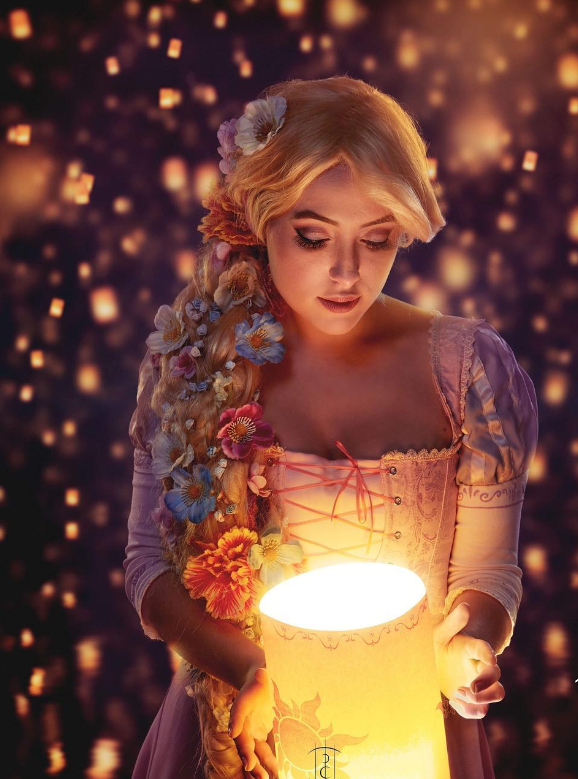 Woman cosplaying as Rapunzel holding a glowing lantern, with flowers in her braided blonde hair.