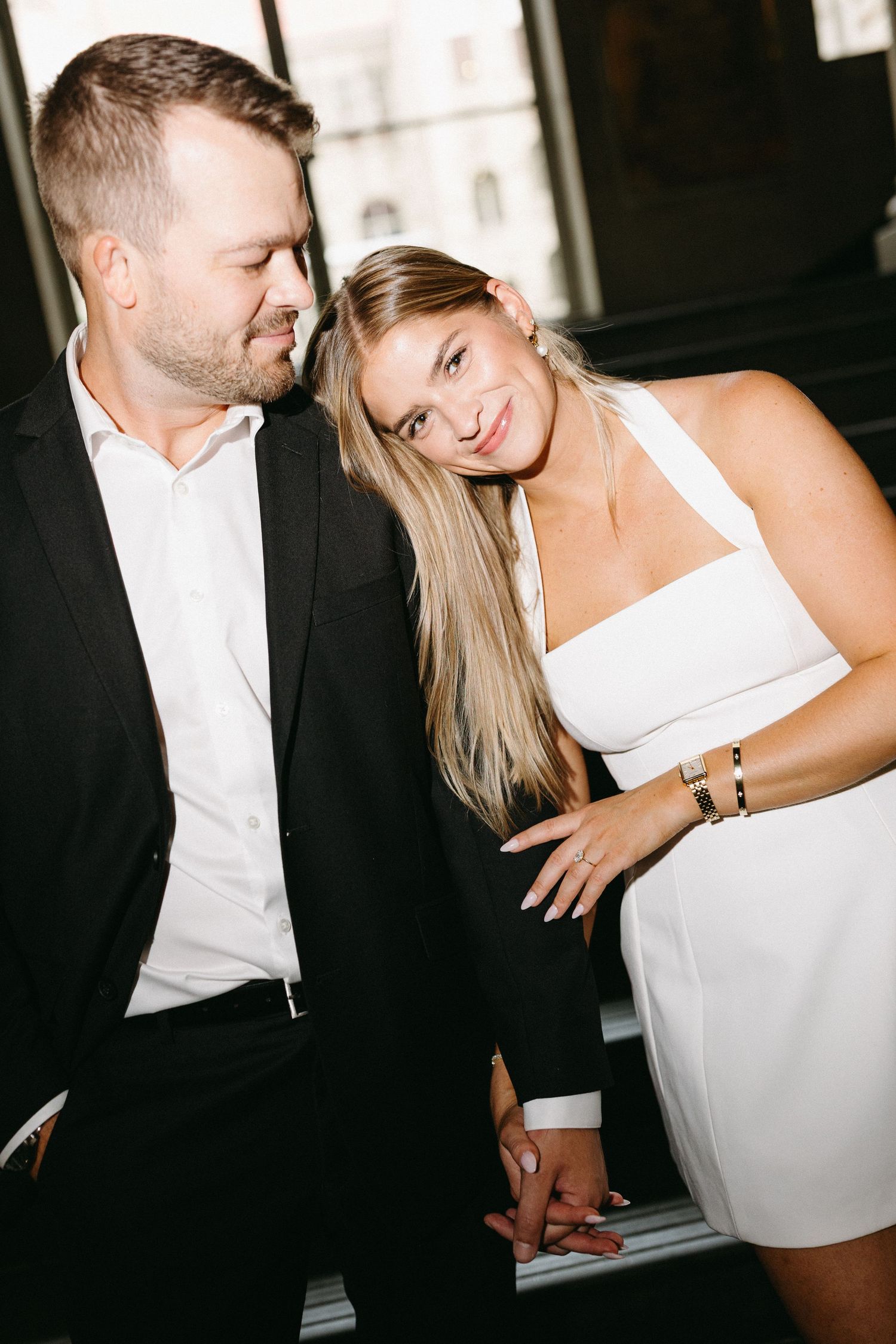 Seven romantic black and white photos show two people in formal attire sharing intimate moments in a low-lit setting.
