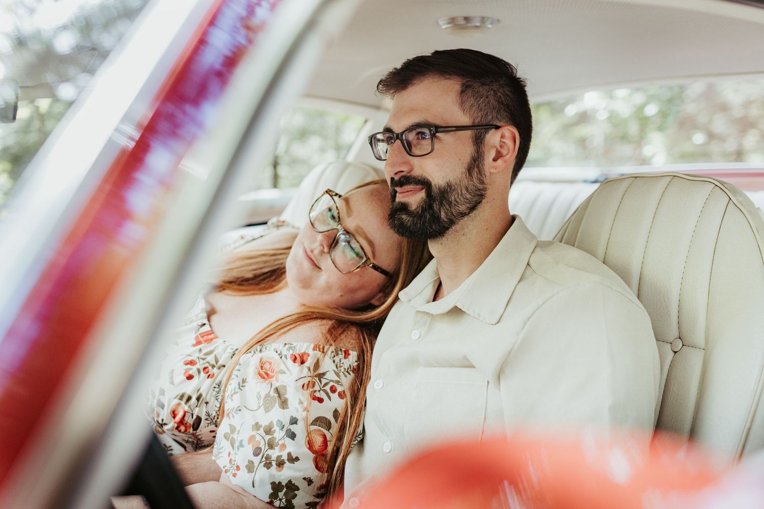 A tender moment captured inside a vintage car with cream leather interior.