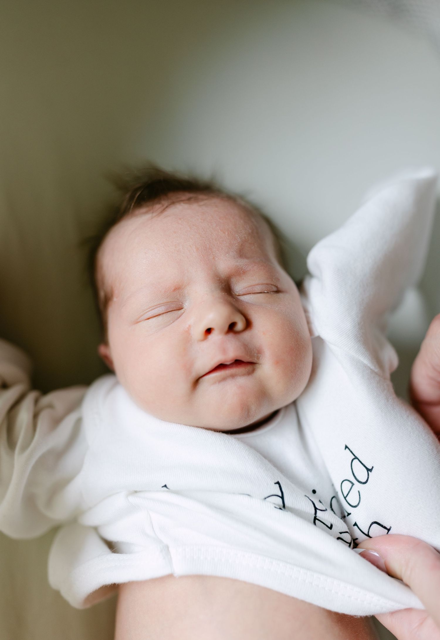 A sleeping baby peacefully rests in soft white bedding in a series of quiet moments.