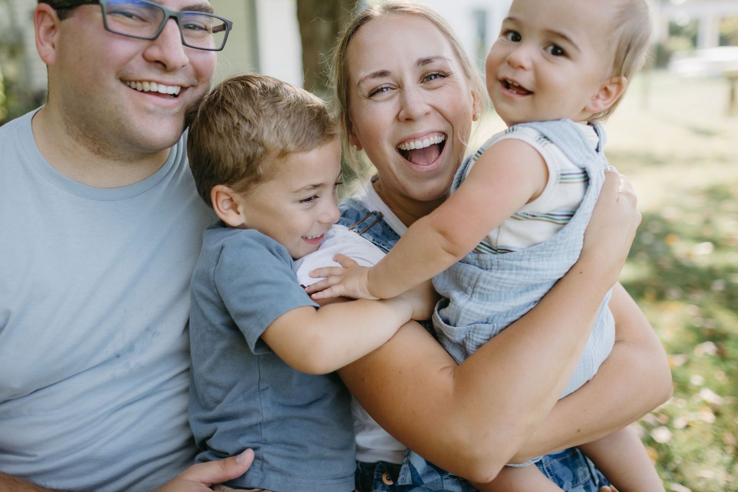 Happy family with two children sharing joyful moment outdoors.