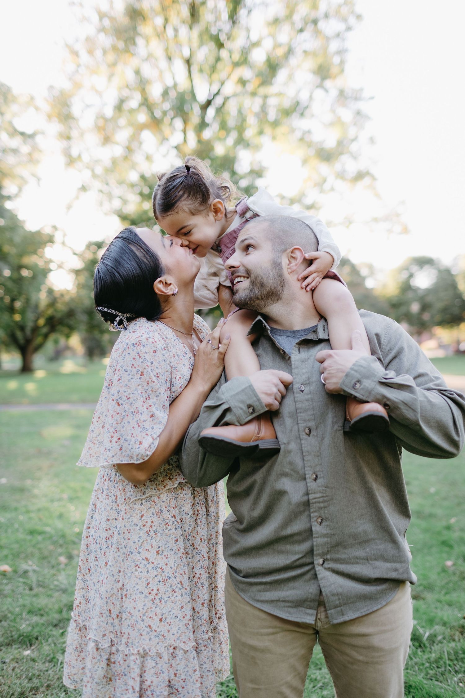 Joyful family moment captured outdoors in park setting during golden hour.