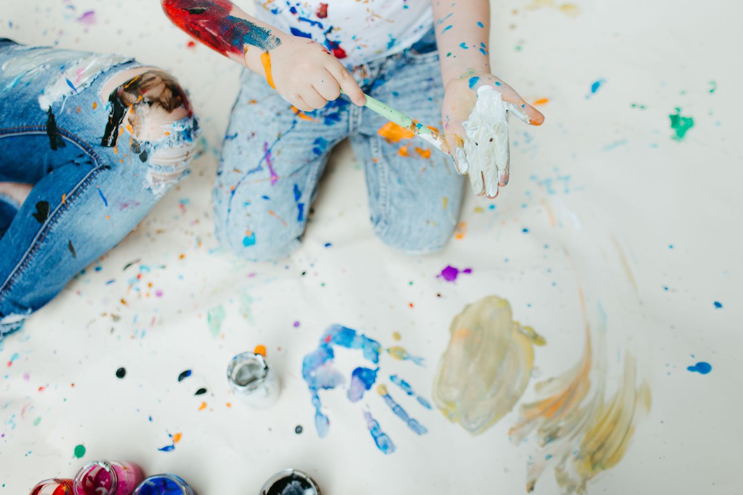 Artistic overhead view of paint splatter and denim during creative photo session.