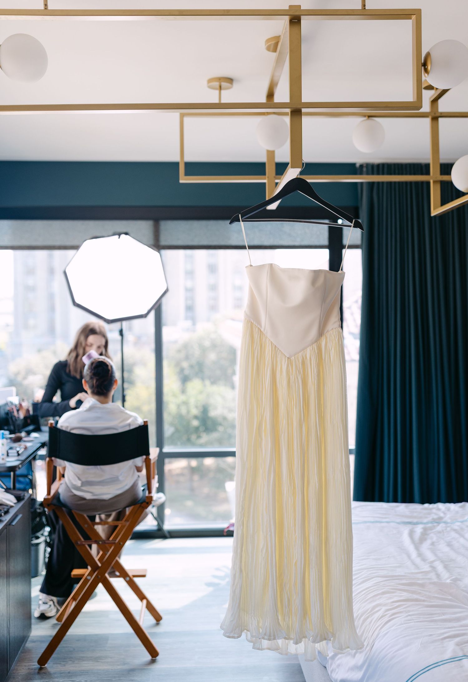 A series of five images showing a white wedding dress hanging and a director's chair in a bright modern room setting.