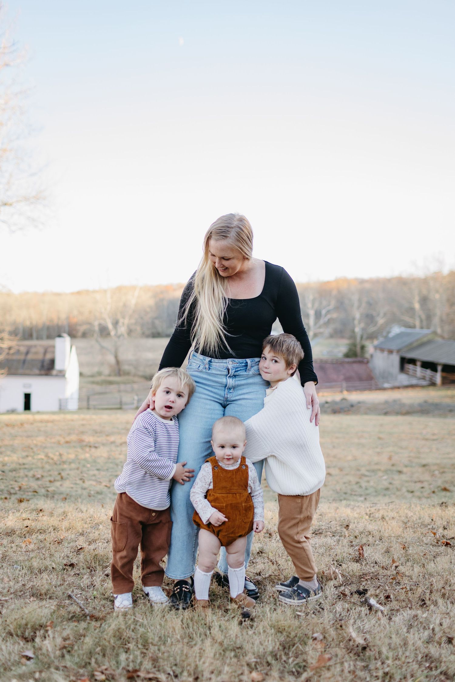 Casual outdoor family moment with children in autumn countryside setting.