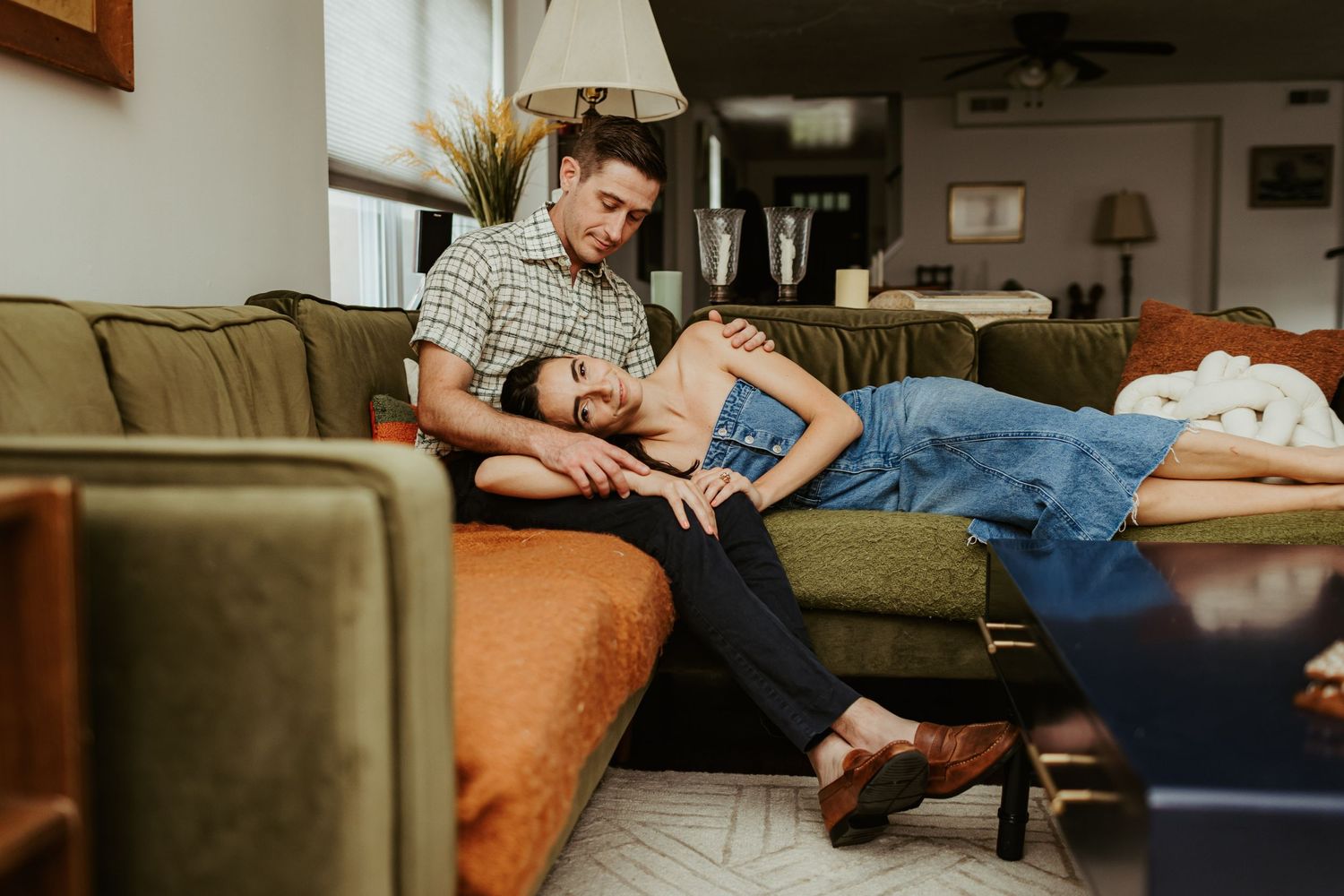 A relaxed lifestyle photo on a tan couch in a cozy living room setting.
