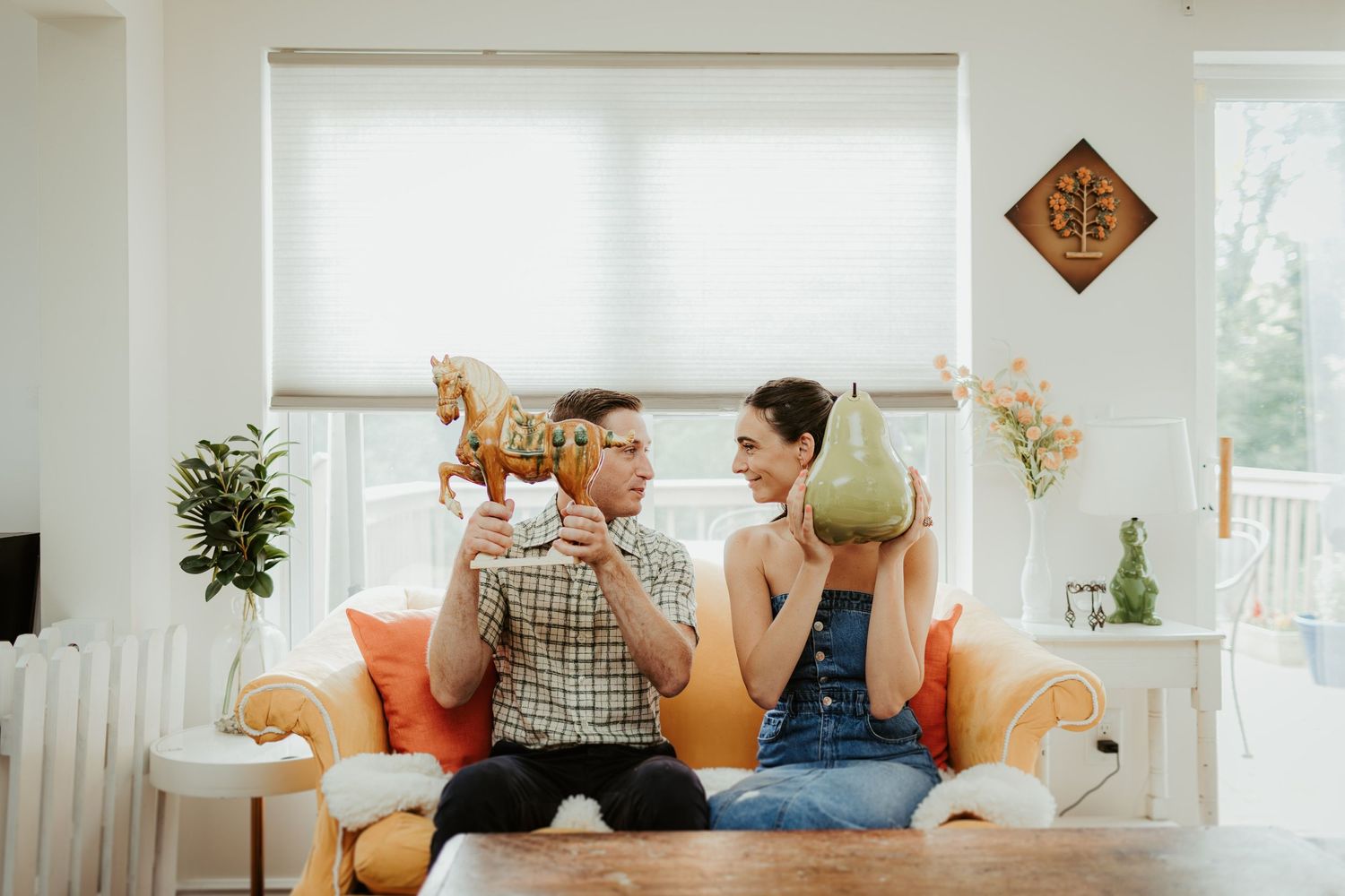 Playful moment shared on an orange couch with decorative wall art.