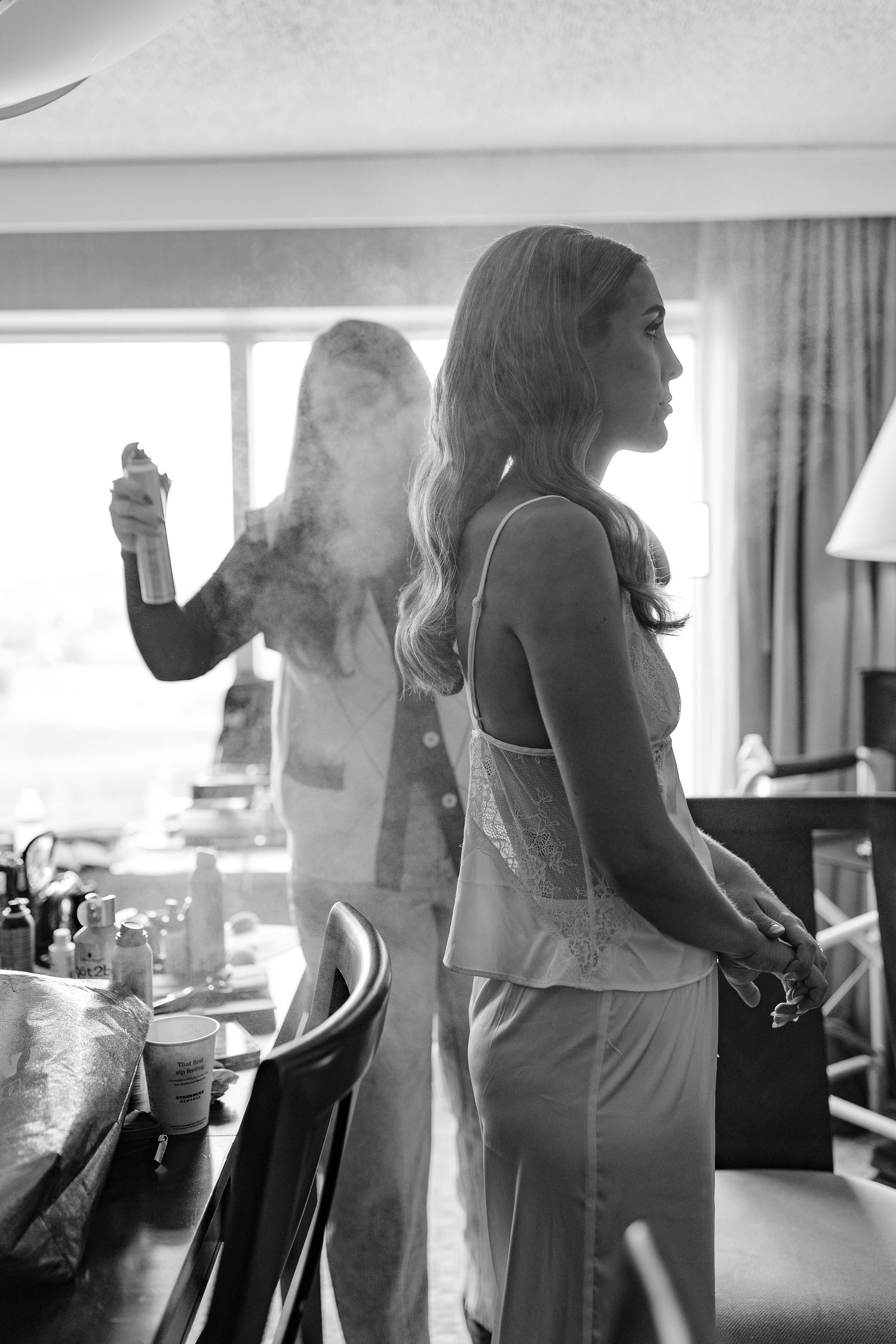 Black and white sequence showing wedding party preparations in a hotel room with figures in formal attire.