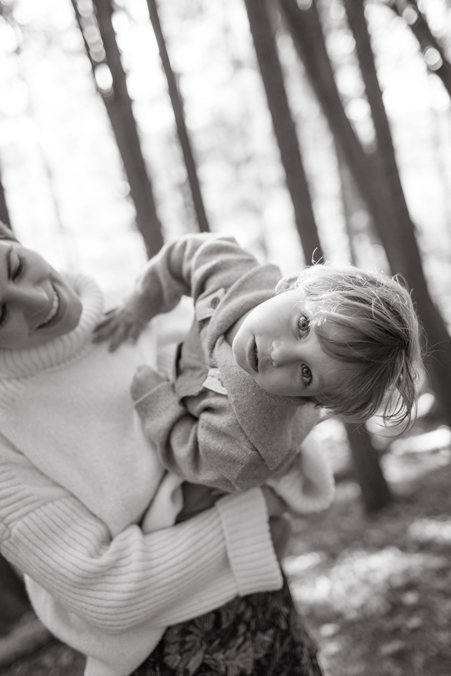 Black and white candid forest portrait with soft bokeh lighting.