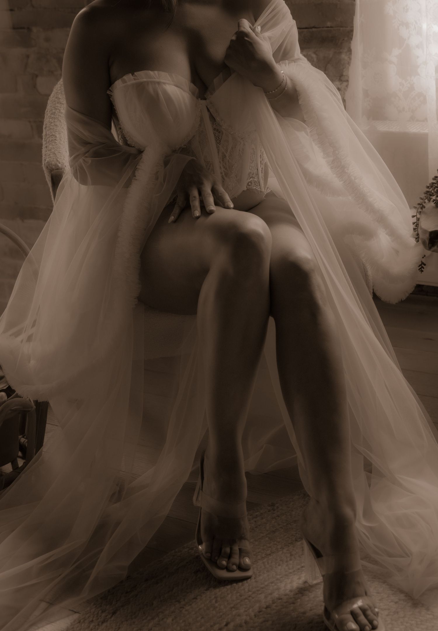 Artistic sepia-toned portrait showcasing delicate white fabric in an intimate setting.