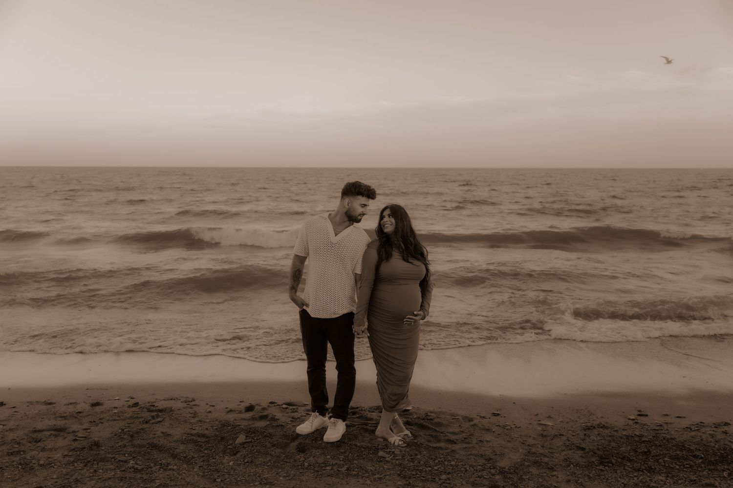 Vintage style photograph of couple standing together on foggy beach.