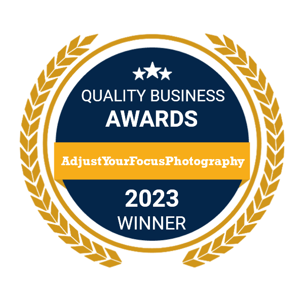 Quality Business Awards 2023 winner badge with gold laurel wreath design for AdjustYourFocusPhotography.
