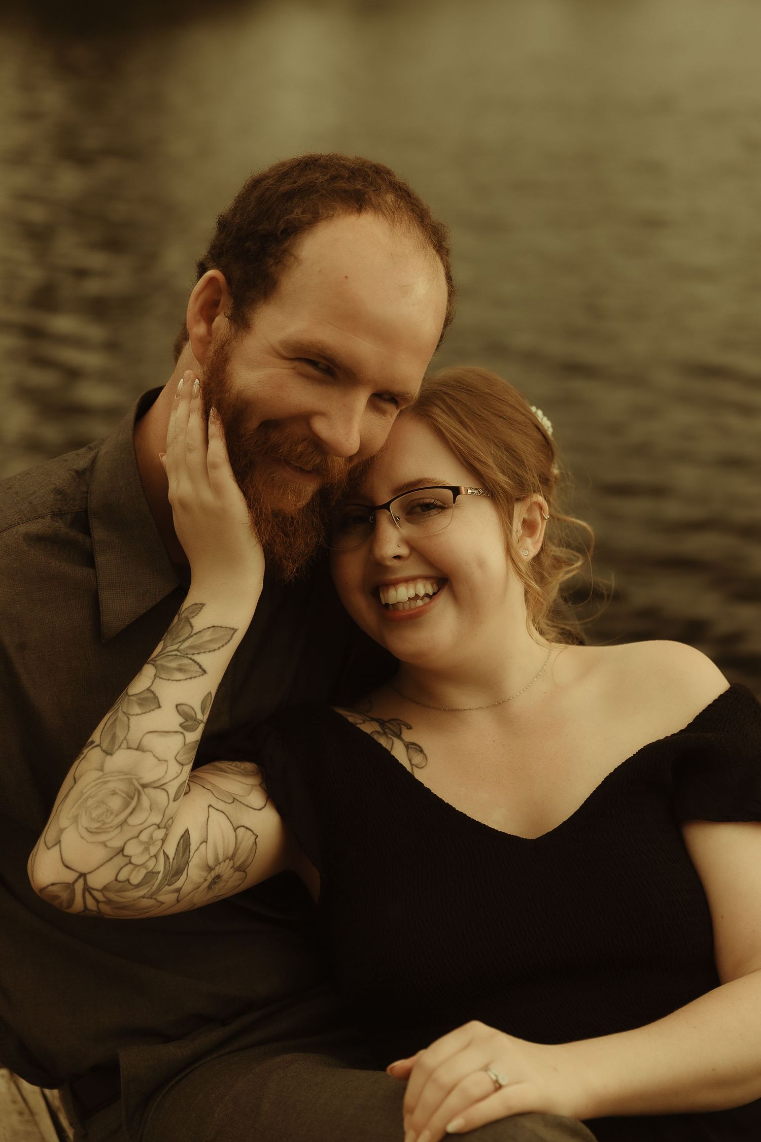 A romantic couple shares intimate moments in a series of sepia-toned photographs by the water.