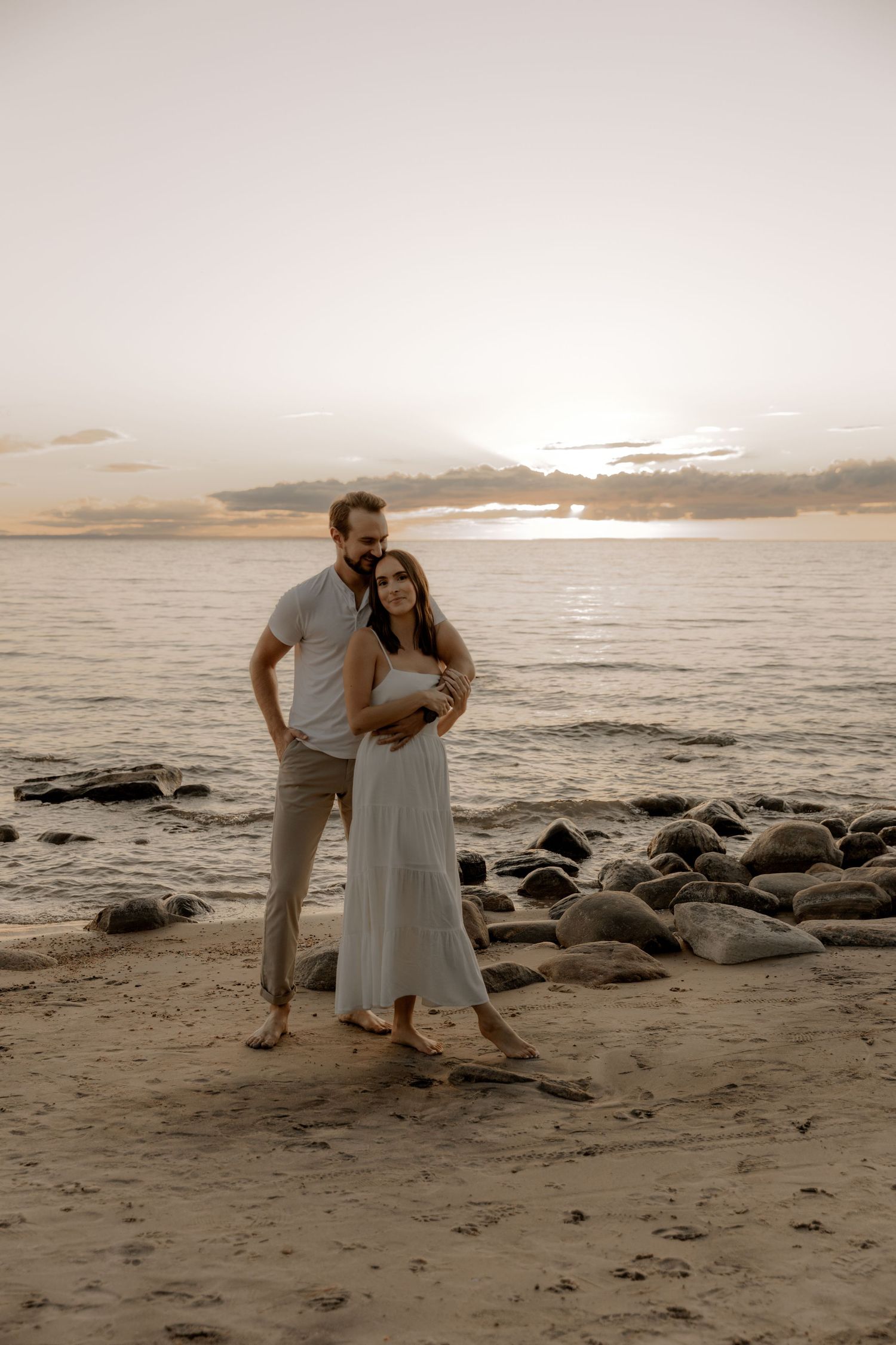 Romantic sunset beach portrait on rocky shoreline.
