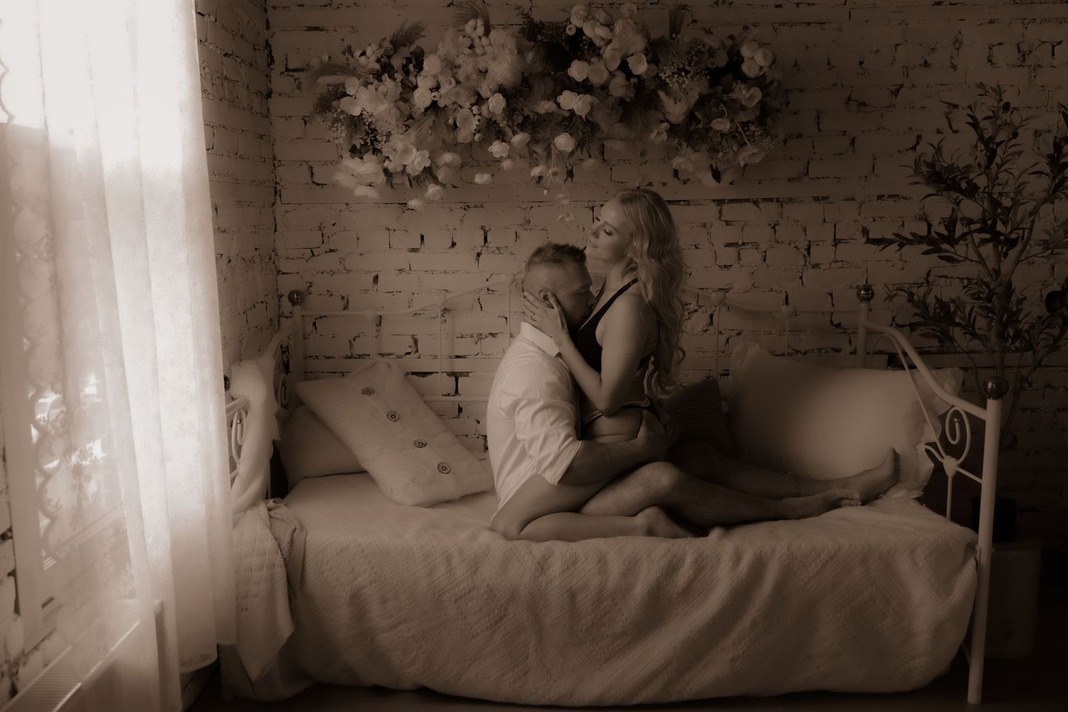 Intimate monochrome portrait session on bed with vintage aesthetic.