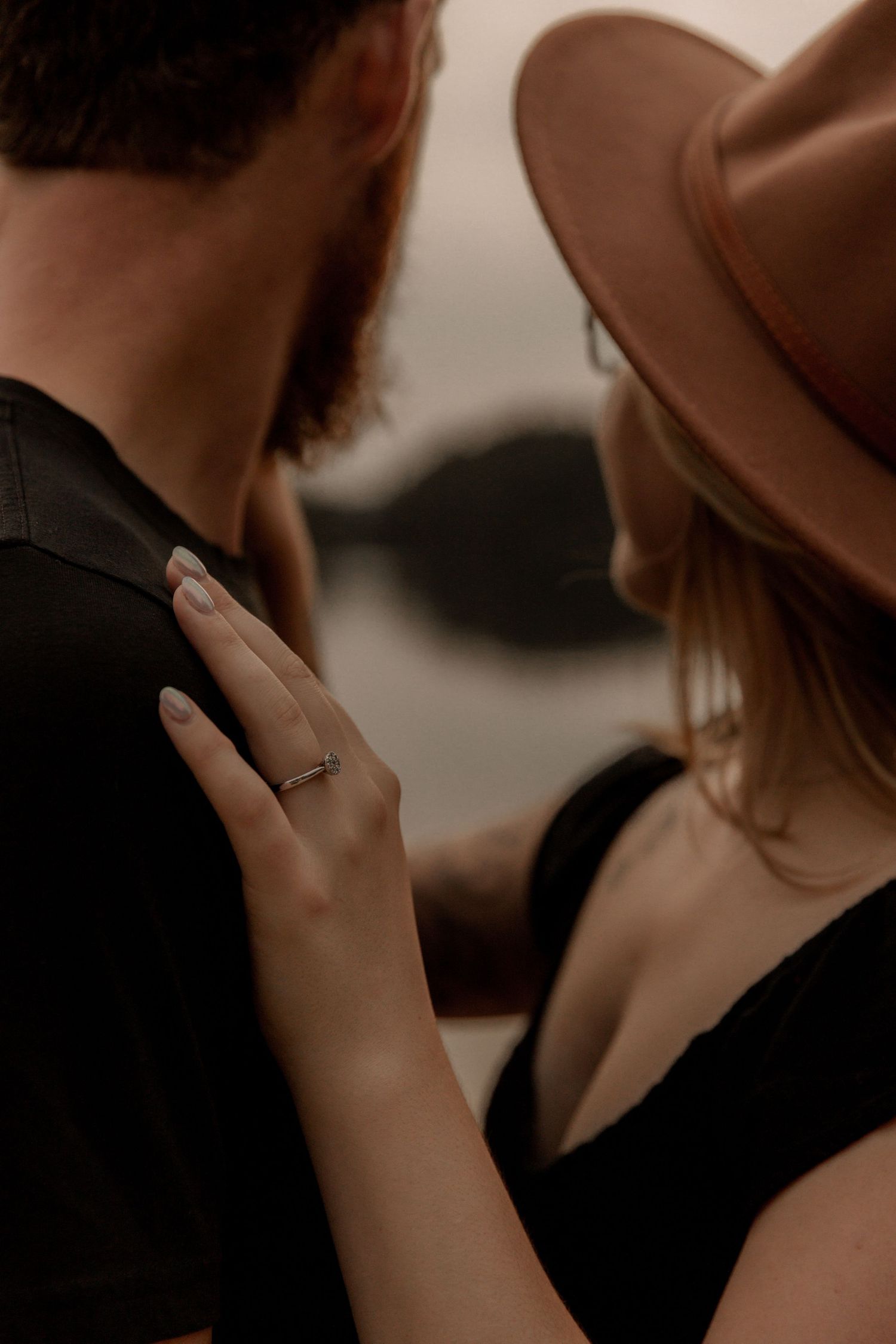 Close up of hands and ring in romantic lakeside engagement photo.