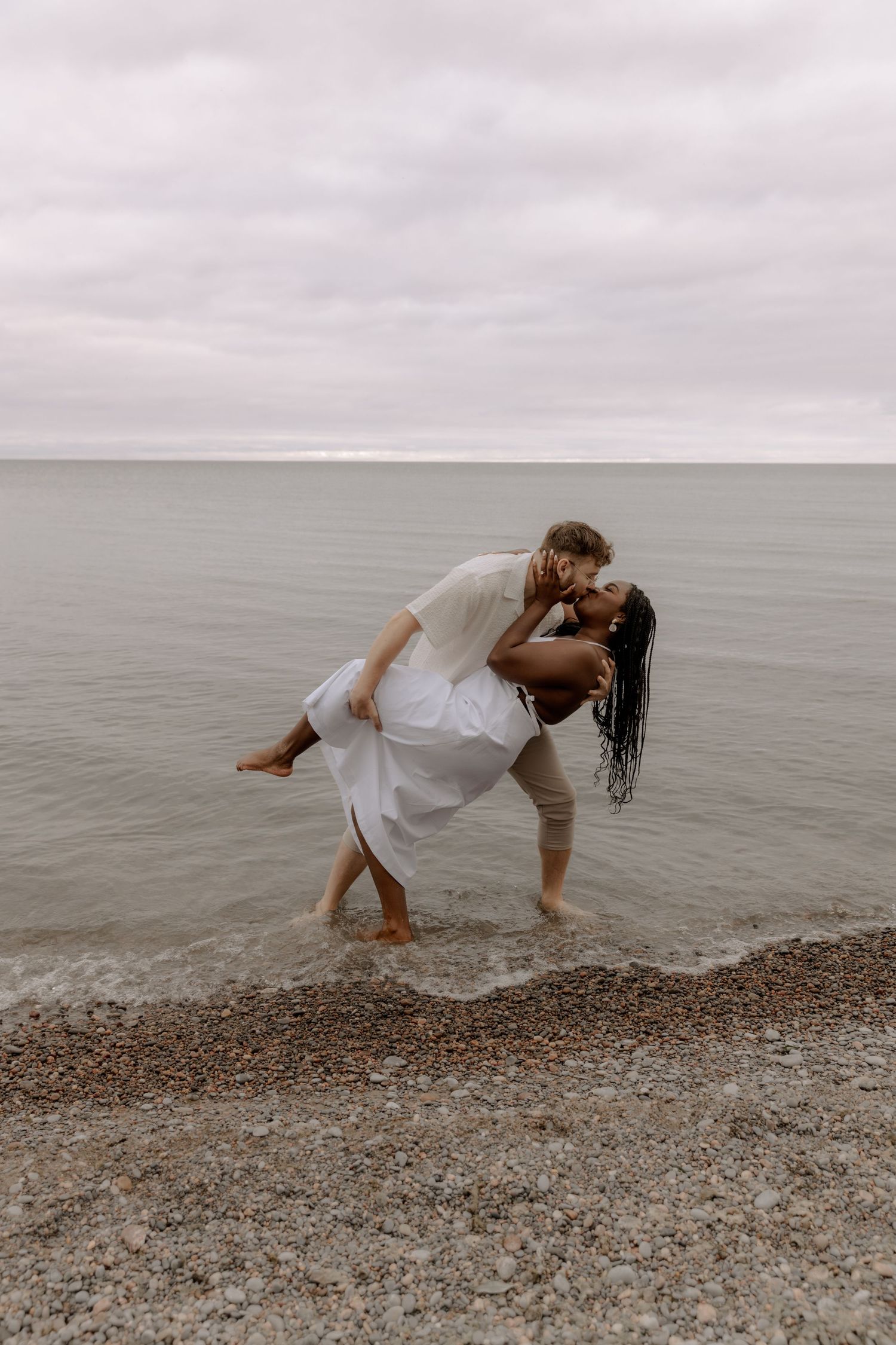 A romantic couple shares a playful moment in the shallow water.