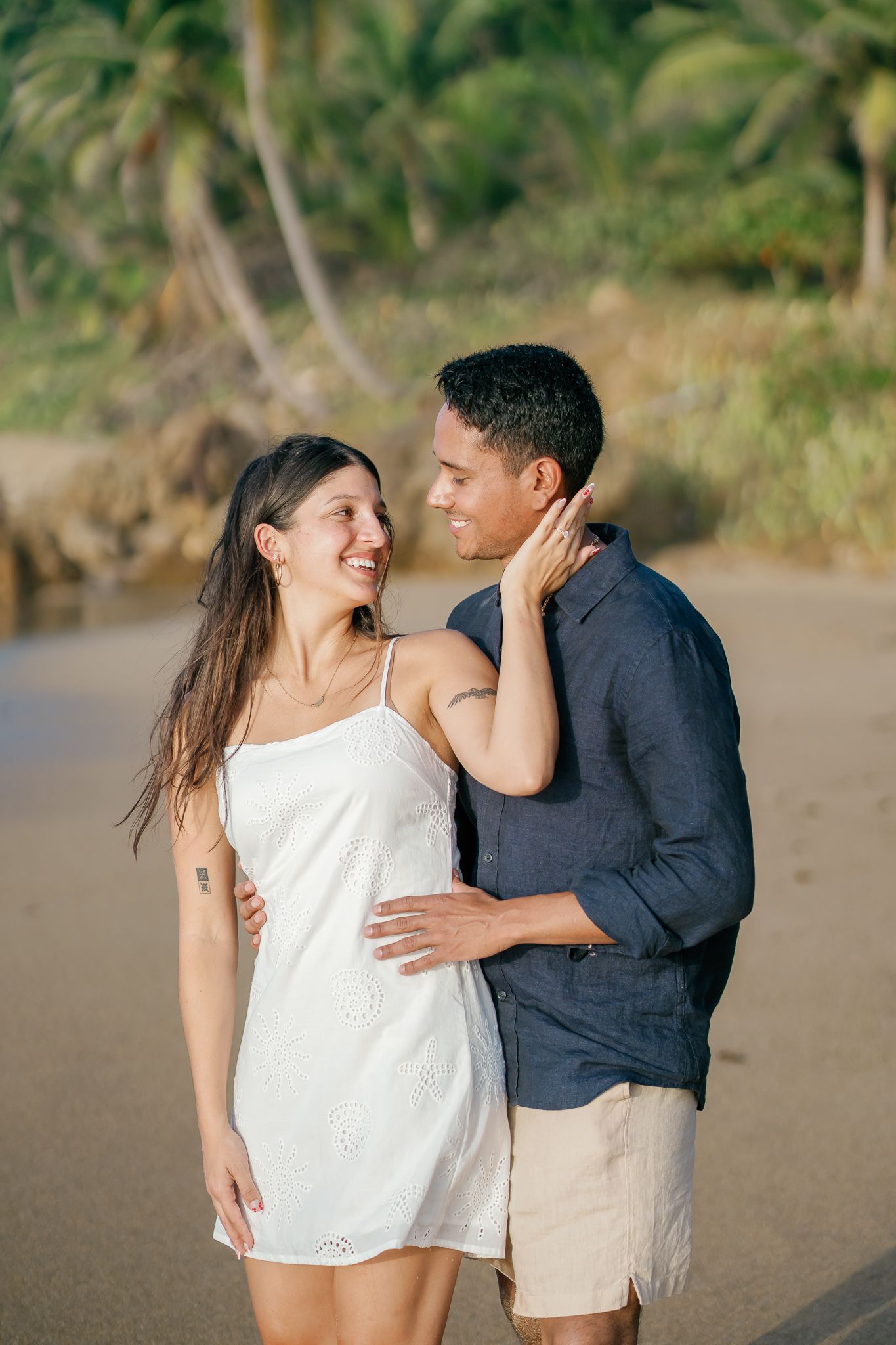 A series of candid photos capturing a couple's intimate interaction on a sandy beach with natural scenery.