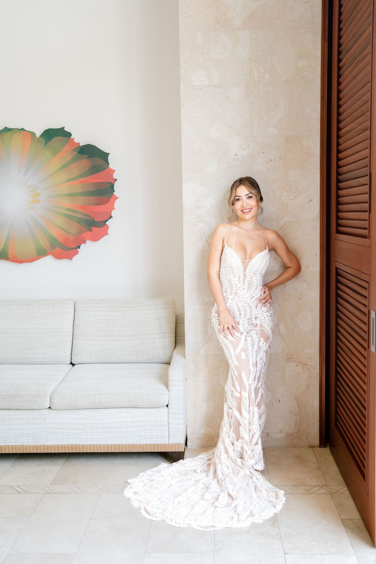 Beautiful lace wedding dress shown in a sequence of photos against white wall with tropical art.
