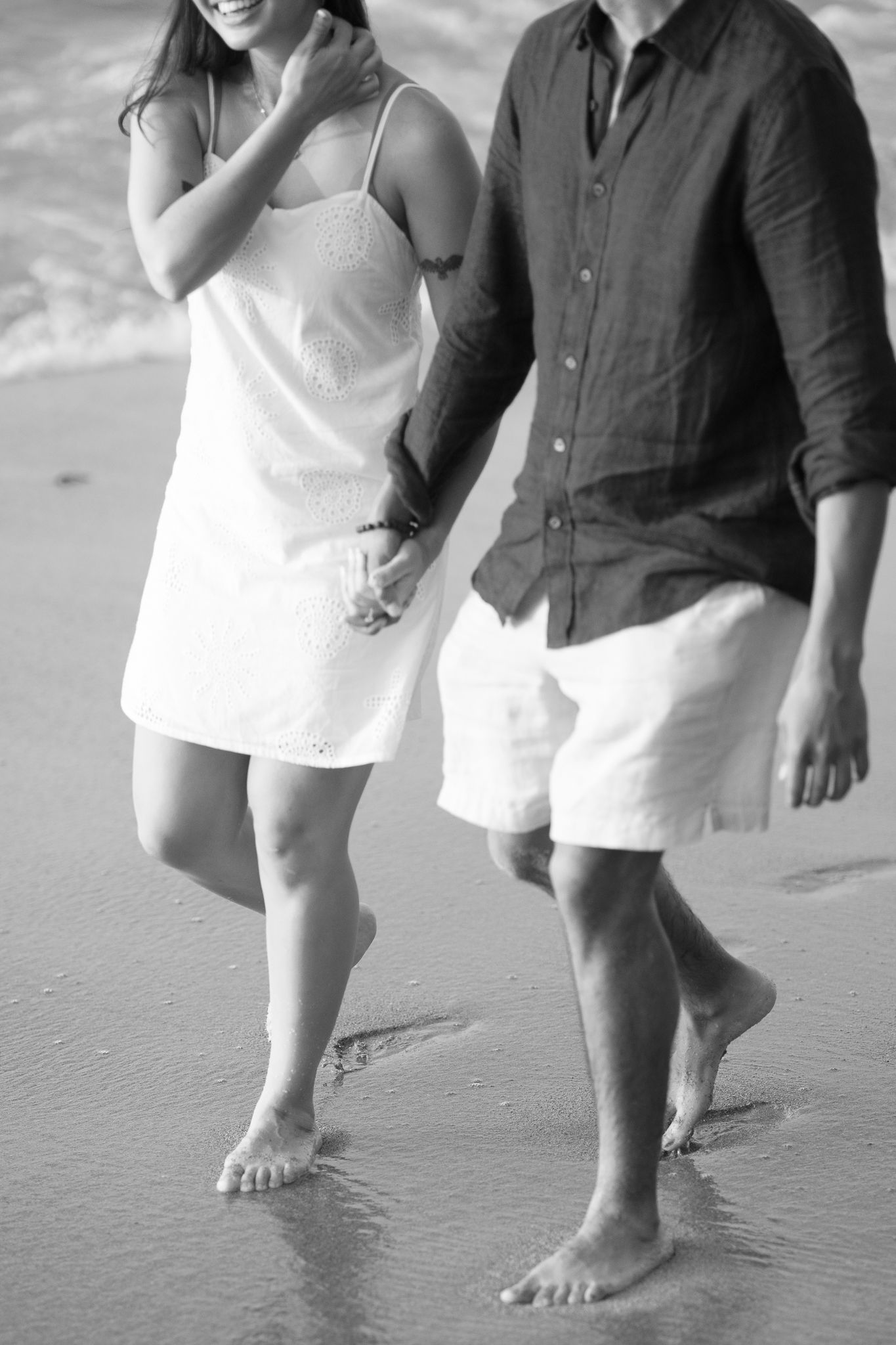 Black and white photo series showing bare feet walking together on a sandy beach.