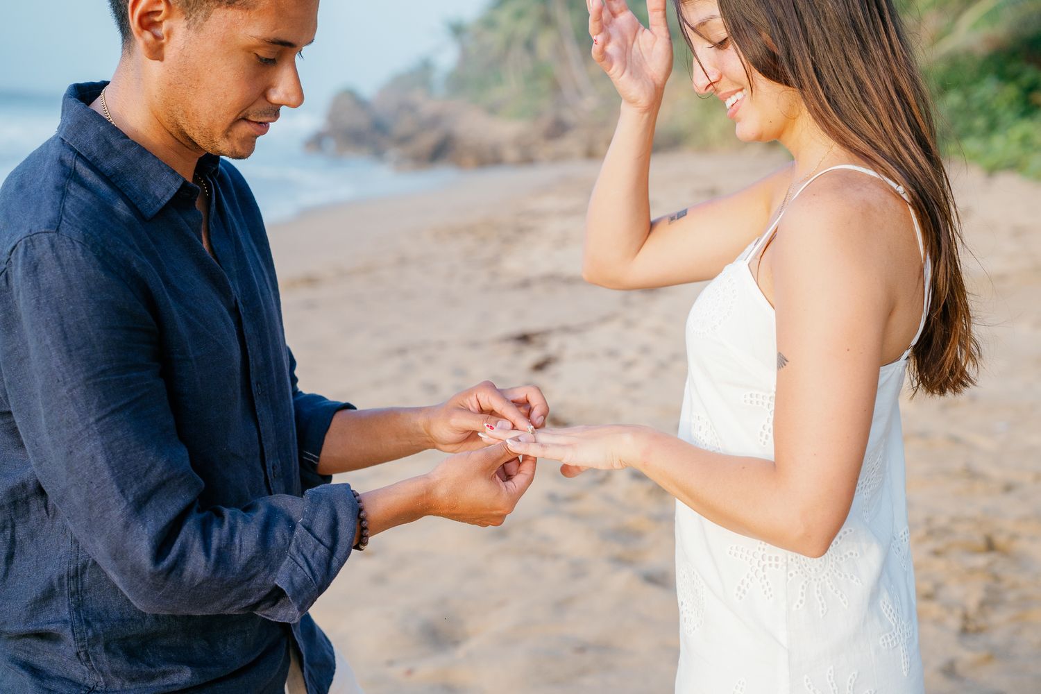 A couple shares a romantic moment on the beach during their proposal as they get engaged at sunset.