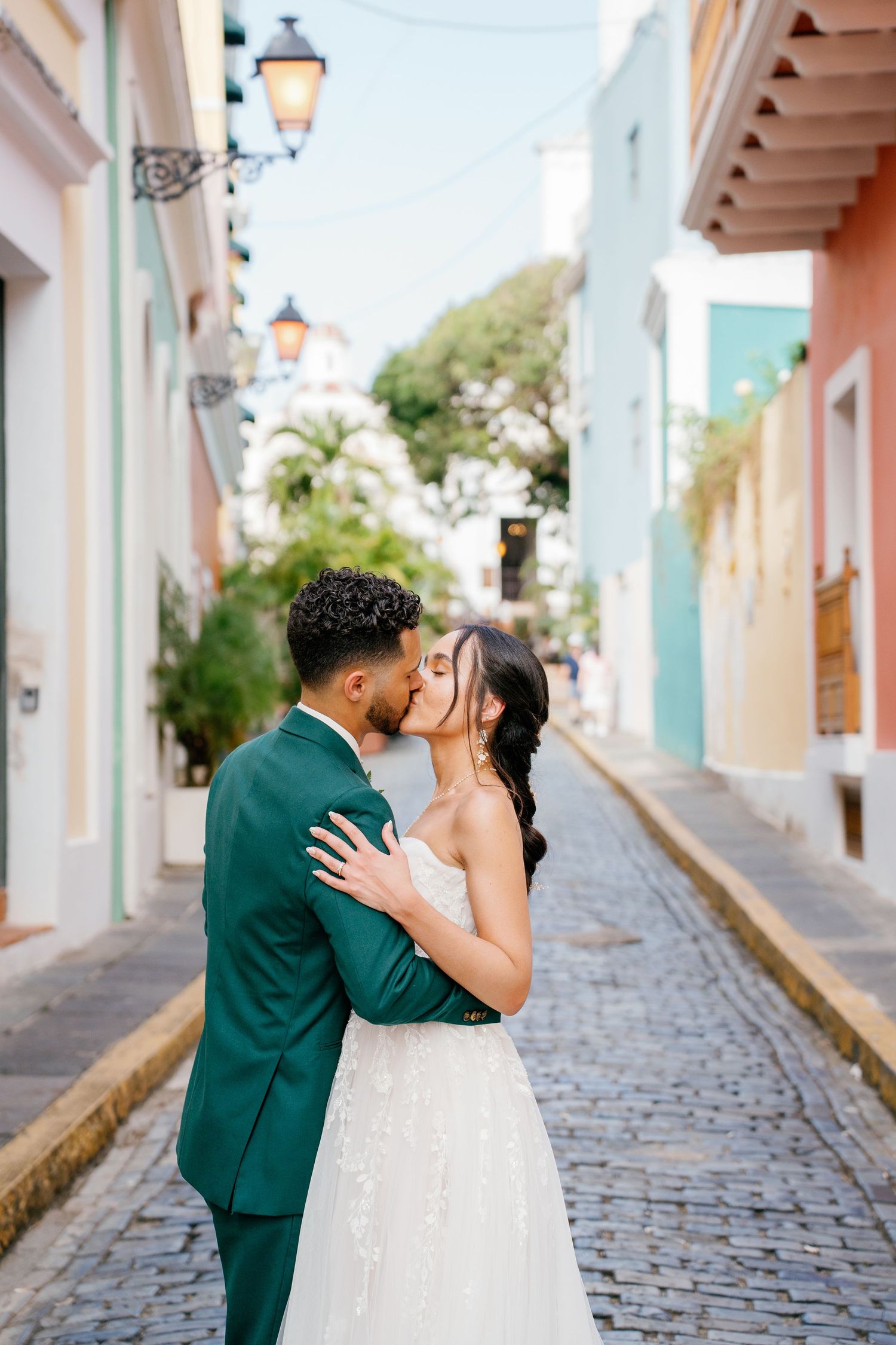 Bride and groom share a romantic kiss on a colorful cobblestone street in Old San Juan, Puerto Rico.