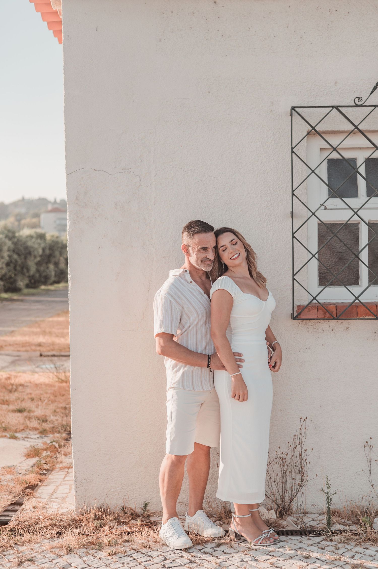Engaged couple sharing an intimate moment in Belém, Lisbon, outdoor photography.