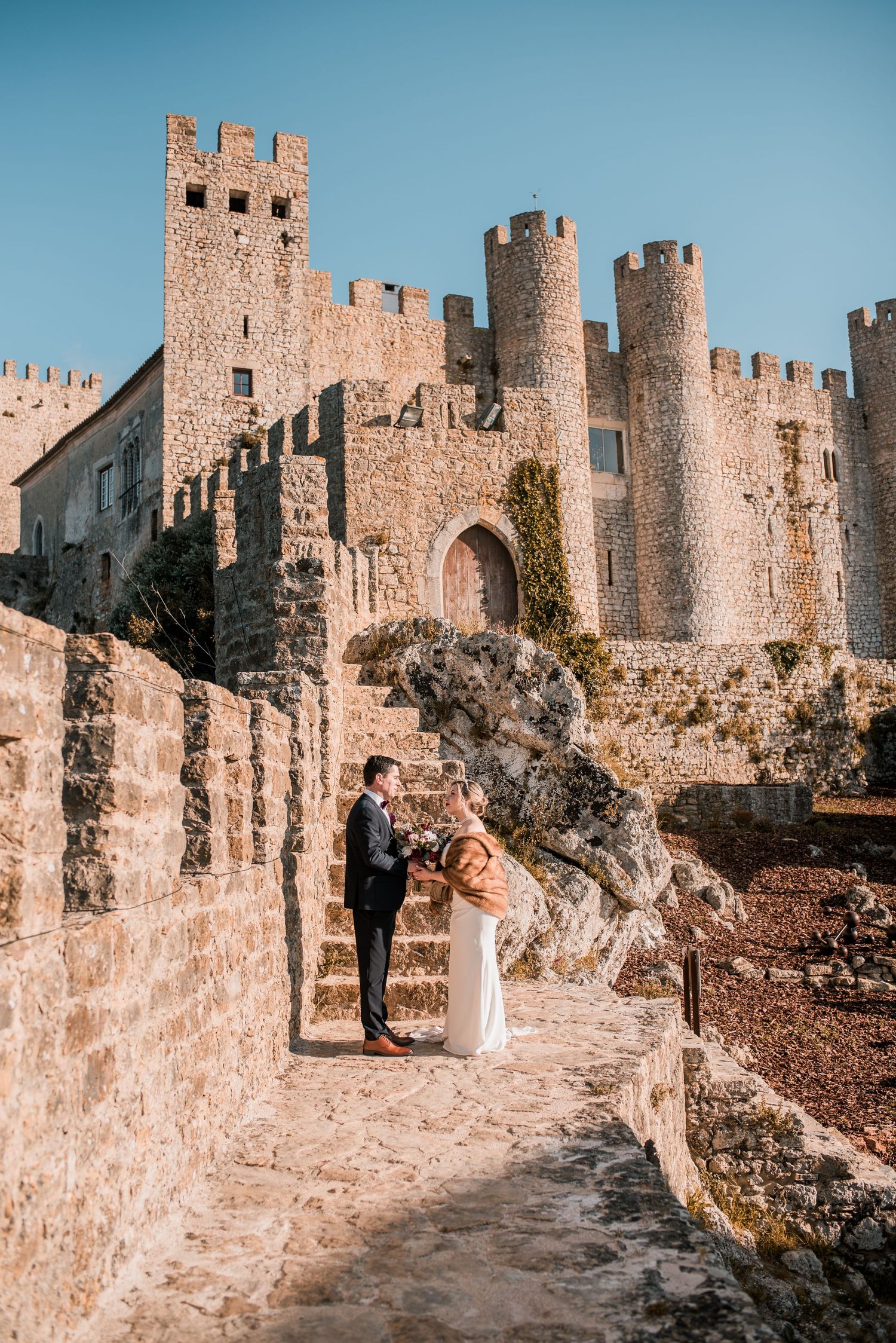 Natural and emotional wedding photography in Óbidos with soft light and historic architecture.