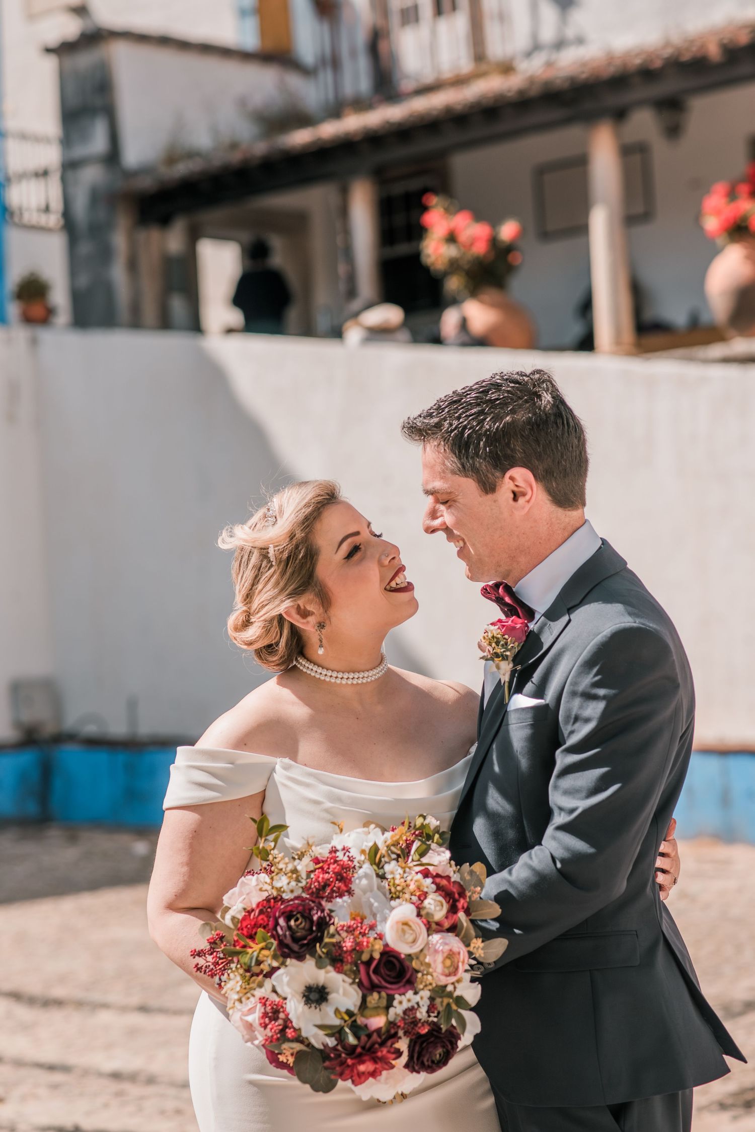 Bride and groom embracing in the historic streets of Óbidos during a destination wedding in Portugal.